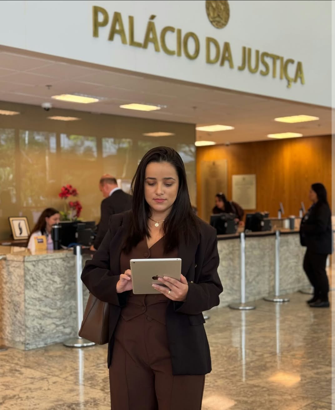 Dra. Josiane Moura no saguão do Palácio da Justiça, consultando um tablet
